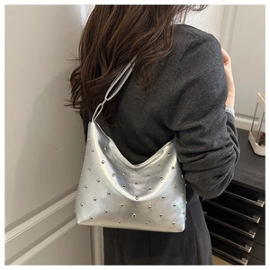 Detail of silver bucket bag with metallic rivets shown on shoulder for daily style
