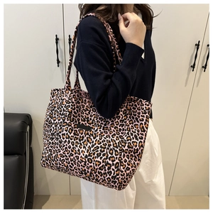 Tragebeispiel einer rosa Canvas-Tasche mit Leopardenmuster und modischem Etikett