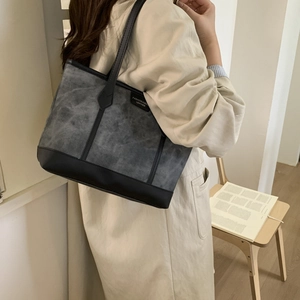 Minimalist dark gray canvas tote bag with black leather trim and long shoulder straps