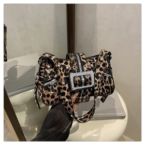Close-up of leopard print shoulder bag with silver studs and metal buckle details