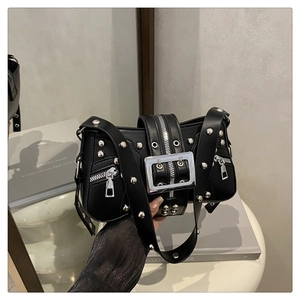 Detail of silver buckles and metal studs on black punk motorcycle shoulder bag
