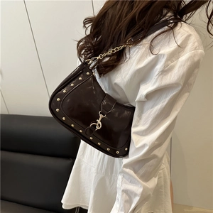 Vintage dark brown crescent bag with gold studs and chain strap on female model