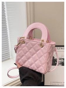 Dettaglio mini borsa rosa trapuntata con finiture dorate e manico curvo