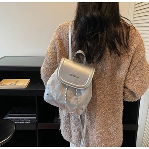 Detail of silver metallic mini backpack featuring chain decor and stylish cat prints