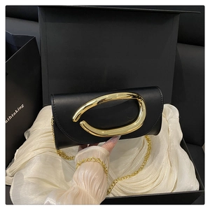 Detail of black leather crossbody bag with gold metallic ring buckle in luxury gift box