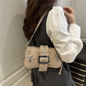 Chic beige Y2K underarm bag with silver rivets and large buckle on a model
