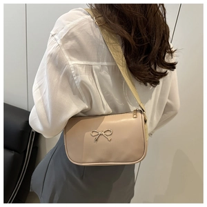 Détail de la bandoulière réglable et du nœud doré sur le sac à bandoulière chic