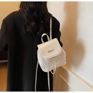 Detail of white mini backpack with metal chain and cute cat print on black coat