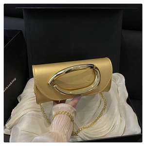 Detail of champagne gold clutch with large metal ring handle in premium gift box