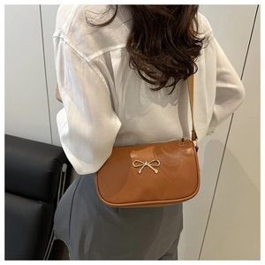 Vue détaillée arrière d'un sac bandoulière marron avec une boucle en nœud doré