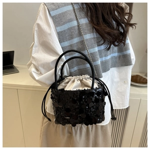 Detail of black sequined bucket bag with satin drawstring pouch and silver chain strap