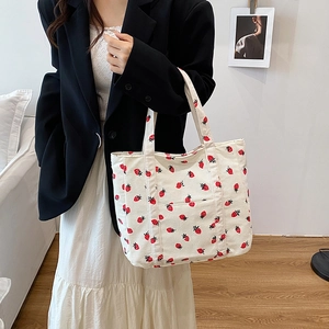 White corduroy tote bag with red strawberry print and front pocket for daily commute