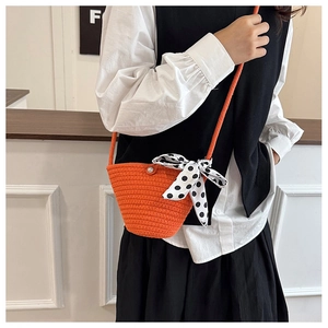 Détail du sac seau tissé orange avec un ruban décoratif à pois noirs et blancs
