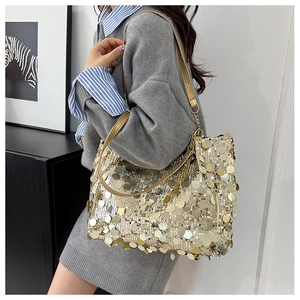 Détail des paillettes dorées scintillantes et de la bandoulière chaîne du sac fourre-tout