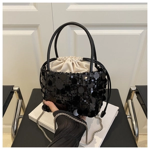 Detail of black sequined bucket bag with beige drawstring lining and silver chain strap