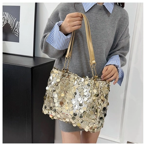 Détail d'un sac cabas à paillettes dorées avec bandoulière en chaîne métallique