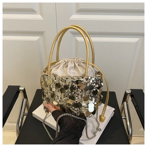 Detail of sequined bucket bag featuring champagne gold sequins and satin drawstring closure