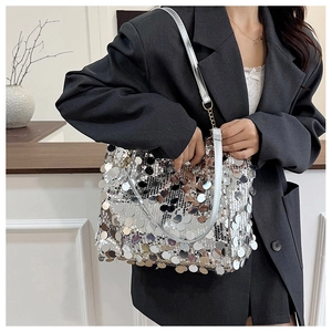 Gros plan du sac à main à paillettes argentées avec chaîne sur un mannequin en blazer