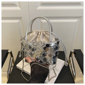 Detail of silver sequin bucket bag featuring drawstring liner and metal chain strap