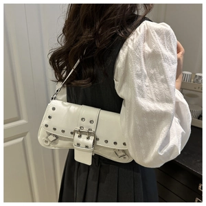 Detail shot of white studded punk shoulder bag with silver hardware and glossy finish