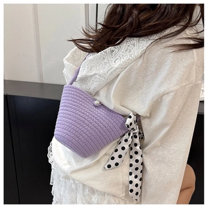 Détail du sac seau violet tissé à la main avec fermoir perle et ruban à pois soyeux