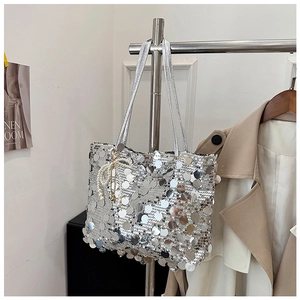Detail of silver sequin shoulder bag with decorative pearls on a modern hanger