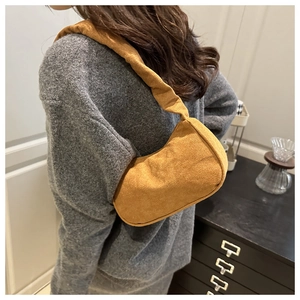 Détail du sac croissant jaune gingembre avec bandoulière plissée en texture suédine