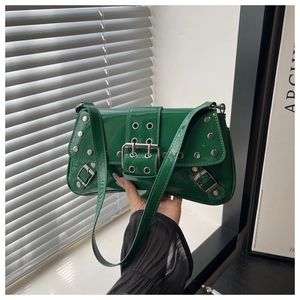 Detailed shot of green patent leather shoulder bag featuring silver rivets and metal buckles