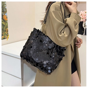 Détail du sac à main à paillettes noires avec bandoulière porté par un mannequin