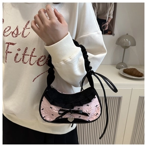 Detail of pink floral jacquard bag with black ruffles and silver heart pendant