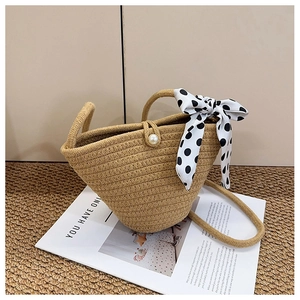 Détail du sac seau tissé en paille avec boucle en perle et décoration de foulard