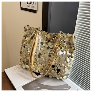 Vue détaillée du sac cabas à paillettes dorées avec bandoulière chaîne sur bois rustique