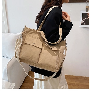 Detail of khaki corduroy tote bag showing large front pockets and shoulder strap