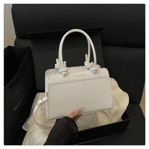 Detail of white PU leather crossbody bag with knot handle and golden metal buckle