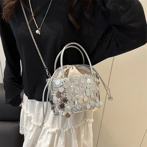 Silver sequin bucket bag with metal handle and chain strap for shoulder or crossbody use