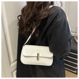 Close-up of white glossy underarm bag featuring a minimalist gold rectangular metal clasp
