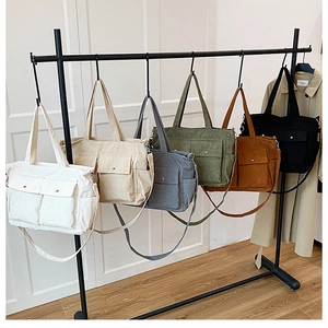Detail view of corduroy tote bags in six colors with front pockets and adjustable straps