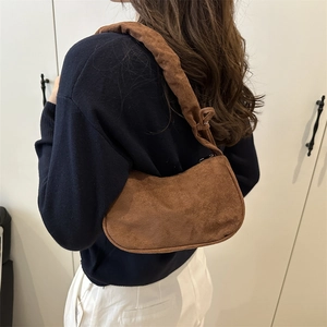 Sac hobo marron en daim au design plissé vintage porté par un mannequin
