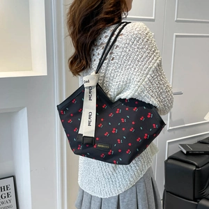 Minimalist black tote bag with red cherry print and wide branded shoulder strap