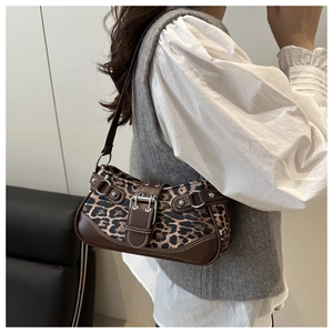 Close-up of leopard print underarm bag with brown leather trim and silver buckle