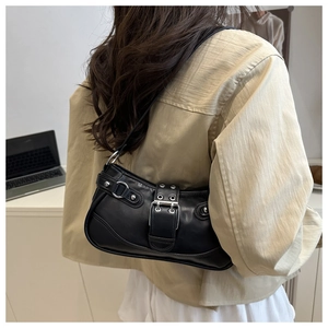 Close-up of black leather underarm bag with silver buckle and eyelet strap details