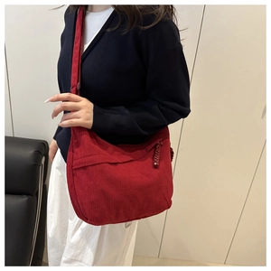 Détail du sac dumpling en velours côtelé rouge avec texture douce et tirette tissée