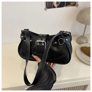 Close-up of black leather underarm bag featuring silver metal eyelets and rivets detail