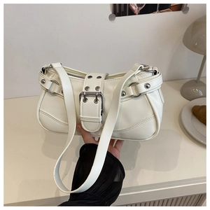 Close-up of white faux leather shoulder bag with decorative straps and silver buckles