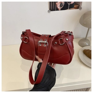Detailed view of dark red leather underarm bag featuring Y2K silver buckles and rivets