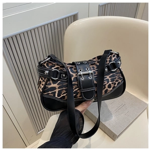 Detail view of leopard print shoulder bag with silver eyelets and buckle accents