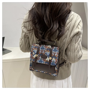 Macro detail of vintage geometric jacquard pattern and premium brown leather trim on backpack