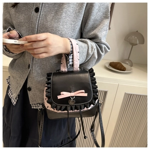 Detailed view of black lace trim and pink bow on a sweet style leather backpack