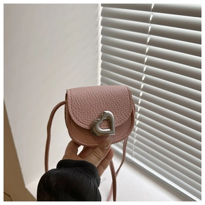 Détail du sac selle rose en cuir grainé avec un fermoir argenté en forme de cœur