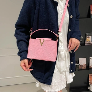 Pink woven leather handbag with gold V-buckle and shoulder strap for elegant women